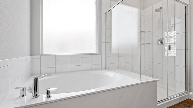 full bathroom featuring a garden tub and a shower stall