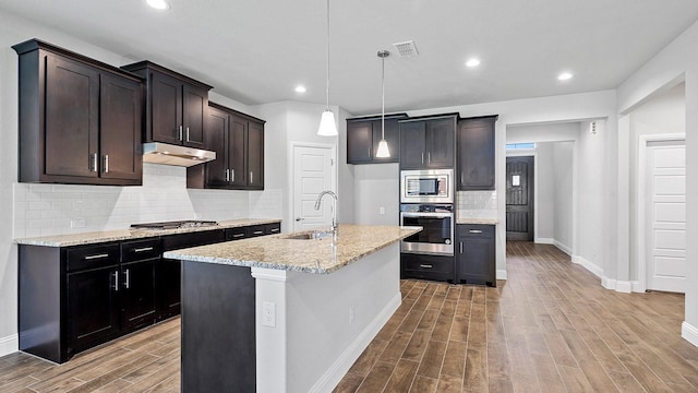 kitchen featuring visible vents, wood finished floors, stainless steel appliances, under cabinet range hood, and a sink