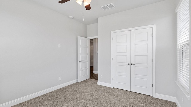 unfurnished bedroom featuring carpet floors, a closet, visible vents, and baseboards