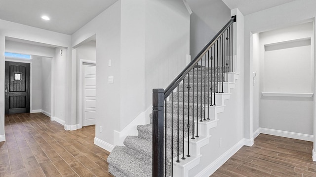 entryway with wood finish floors, baseboards, and recessed lighting