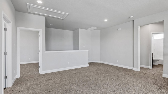 carpeted spare room with baseboards, a textured ceiling, attic access, and recessed lighting