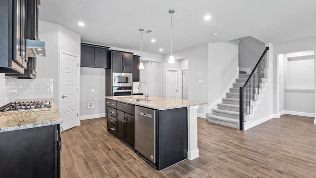 kitchen featuring dark wood-style floors, decorative backsplash, appliances with stainless steel finishes, a sink, and under cabinet range hood