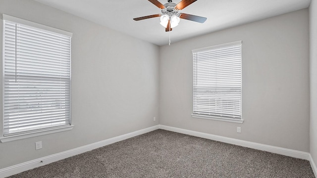 carpeted spare room featuring plenty of natural light, baseboards, and a ceiling fan