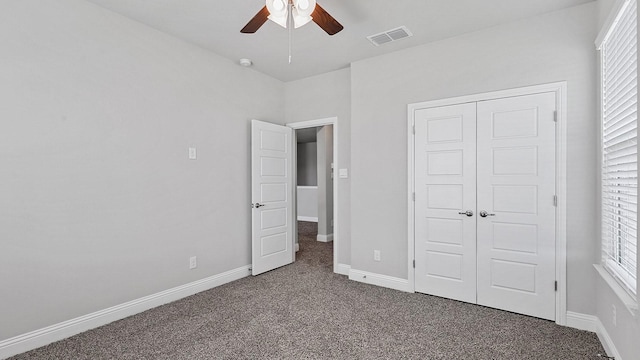 unfurnished bedroom with a closet, visible vents, carpet flooring, ceiling fan, and baseboards