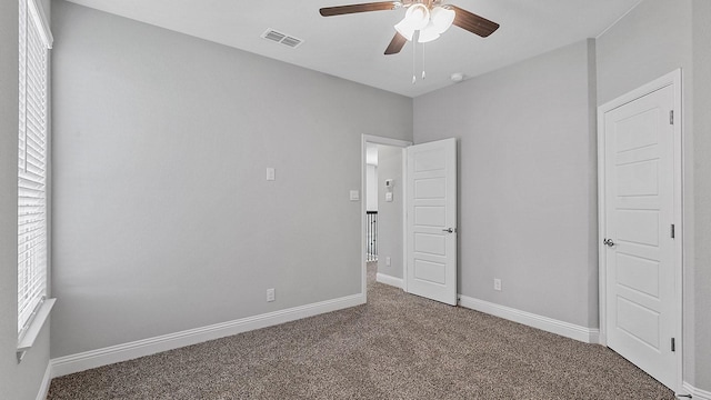 unfurnished bedroom with ceiling fan, carpet flooring, visible vents, and baseboards