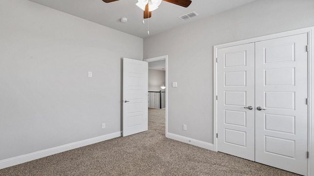 unfurnished bedroom with carpet flooring, a ceiling fan, visible vents, baseboards, and a closet