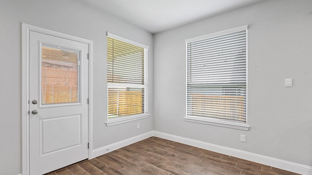 interior space featuring dark wood-style flooring and baseboards