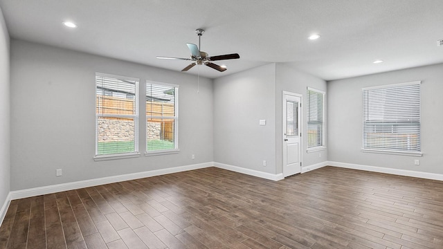 spare room featuring recessed lighting, dark wood finished floors, a ceiling fan, and baseboards