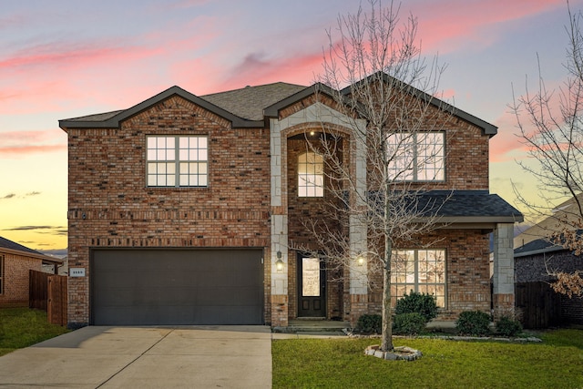 traditional-style home featuring brick siding, a front lawn, fence, a garage, and driveway