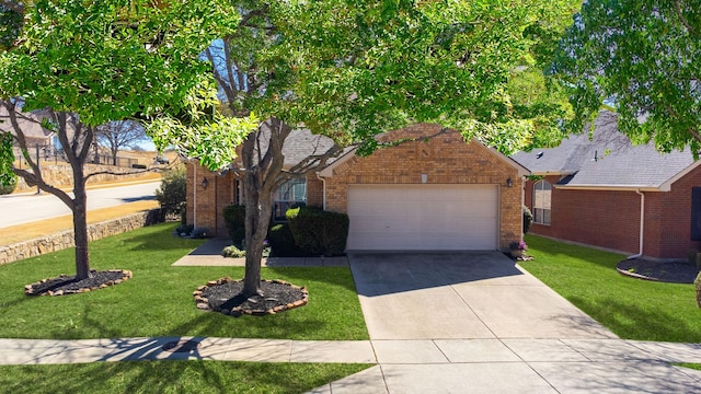 view of front of house featuring a front lawn, brick siding, driveway, and an attached garage