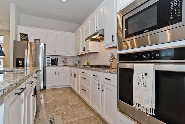 kitchen with stainless steel appliances, white cabinetry, under cabinet range hood, and decorative backsplash