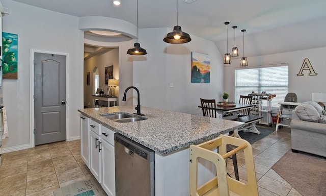 kitchen featuring white cabinets, dishwasher, light stone counters, open floor plan, and a sink