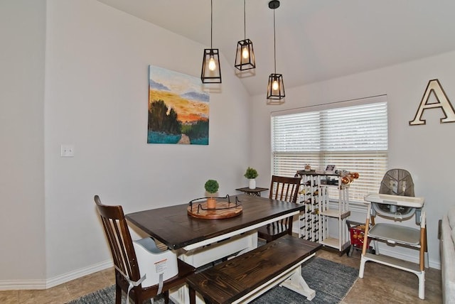 dining room featuring baseboards and vaulted ceiling