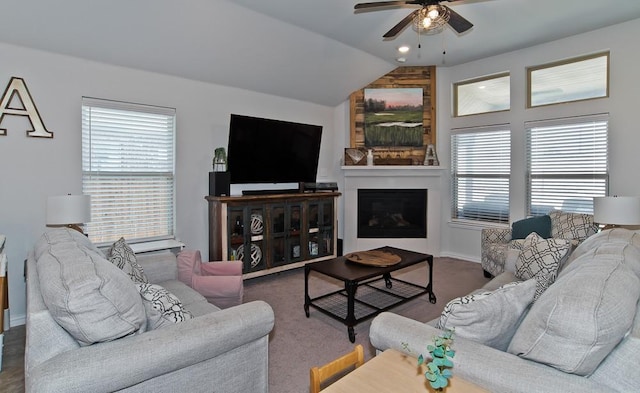 living room with vaulted ceiling, carpet floors, a fireplace, and a ceiling fan