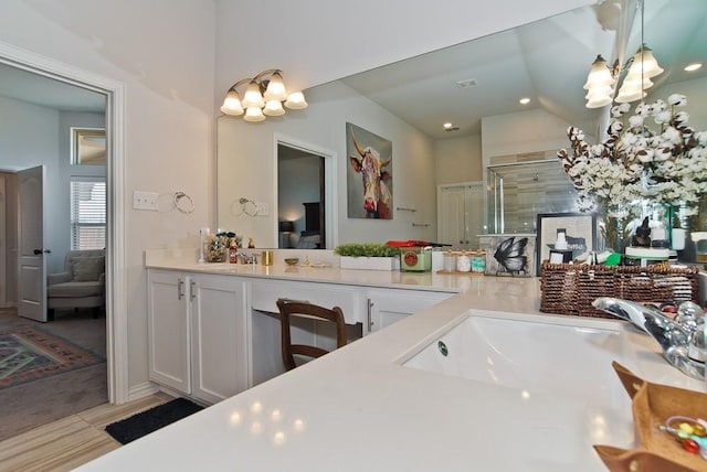 ensuite bathroom featuring a stall shower, ensuite bath, a chandelier, and vanity