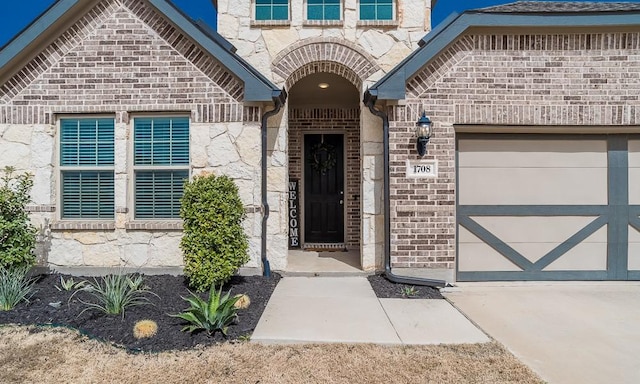 property entrance featuring an attached garage and brick siding