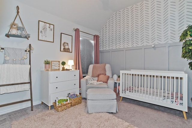 carpeted bedroom with a nursery area and a decorative wall