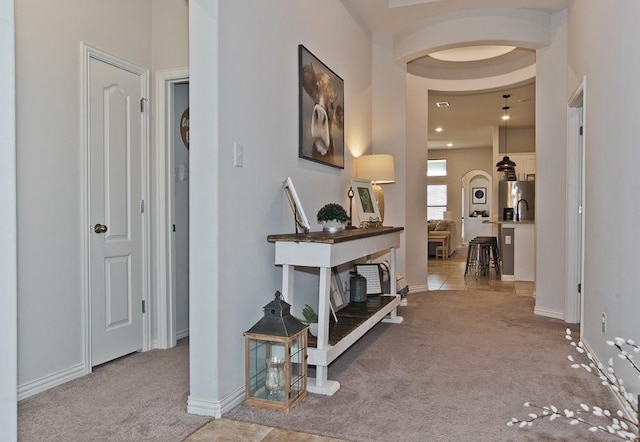 hallway with carpet floors and baseboards