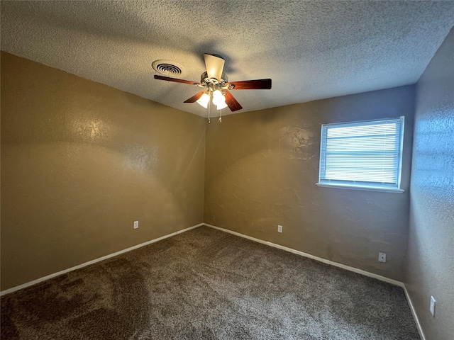 spare room with a textured ceiling, a textured wall, and carpet