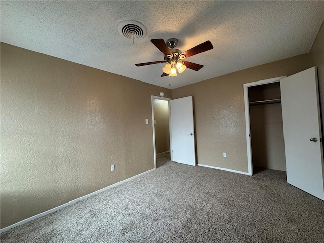 unfurnished bedroom with a textured ceiling, a textured wall, carpet flooring, visible vents, and a closet