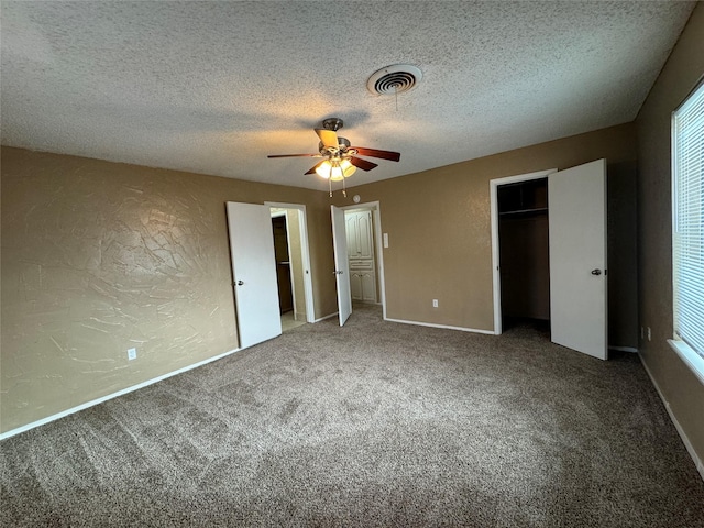 unfurnished bedroom featuring visible vents, a textured wall, ceiling fan, carpet flooring, and a textured ceiling