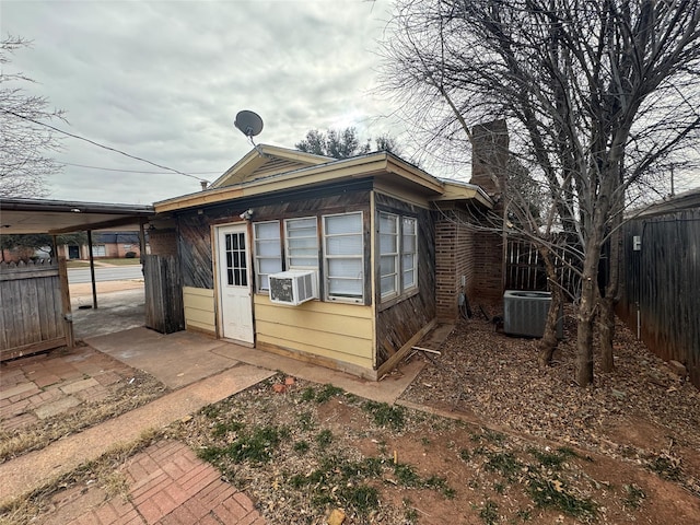 exterior space featuring cooling unit, fence, and a chimney