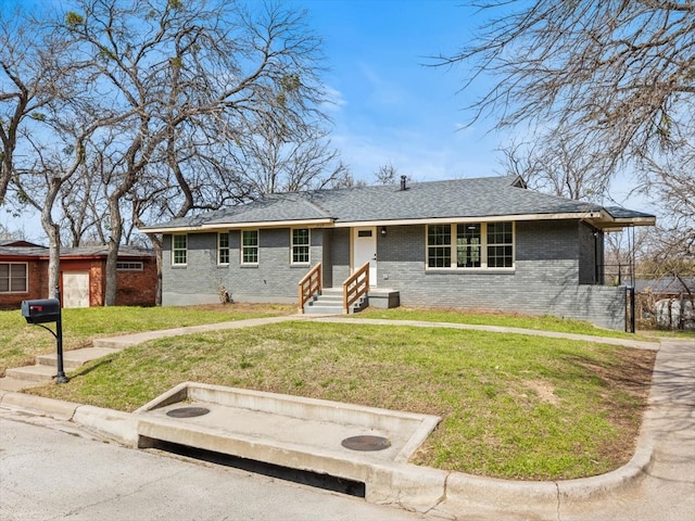 single story home featuring entry steps, a front lawn, a shingled roof, and brick siding