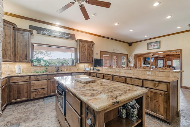 kitchen with a peninsula, a kitchen island, decorative backsplash, and a sink