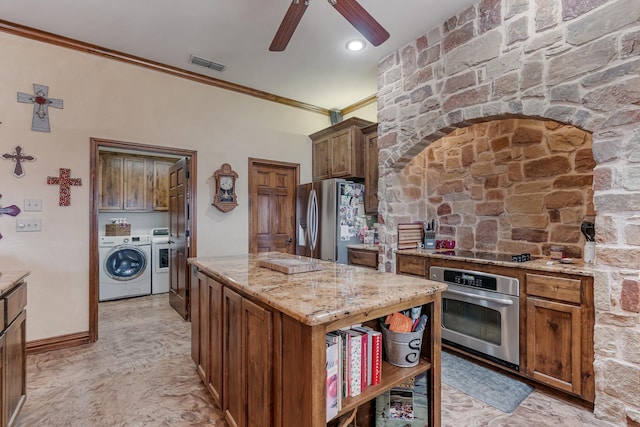 kitchen featuring washing machine and dryer, stainless steel appliances, visible vents, open shelves, and crown molding