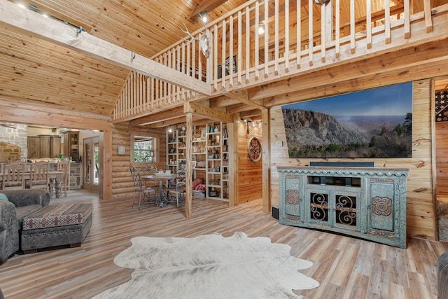 living area with high vaulted ceiling, rustic walls, wood finished floors, and wood ceiling