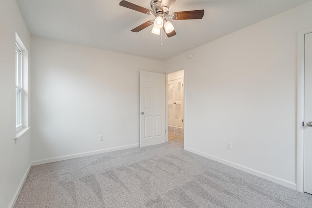 spare room with carpet floors, baseboards, and a ceiling fan