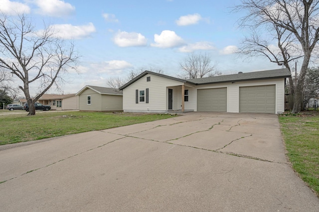 view of front of home with concrete driveway, a front lawn, and an attached garage