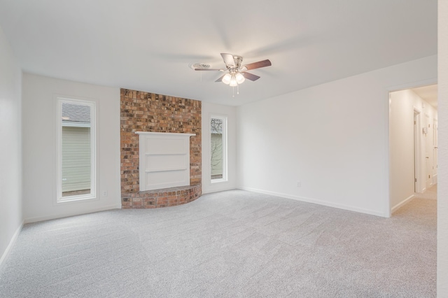 unfurnished living room with ceiling fan, a fireplace, baseboards, and carpet flooring