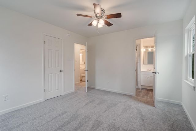 unfurnished bedroom featuring ceiling fan, baseboards, carpet flooring, and ensuite bathroom