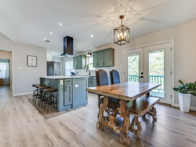 dining room with light wood-style flooring, a chandelier, and plenty of natural light