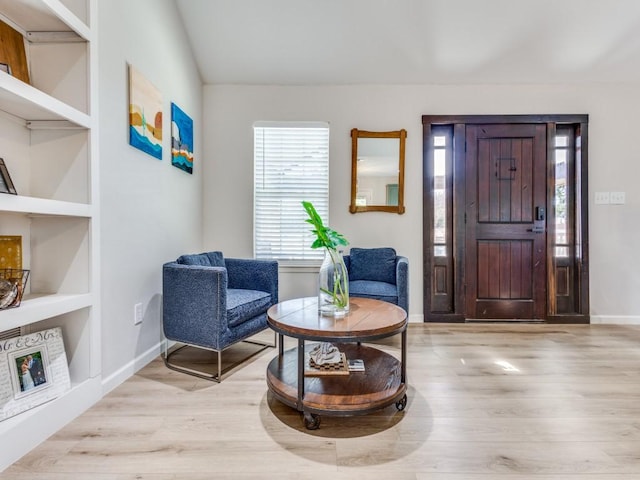foyer entrance with baseboards and wood finished floors