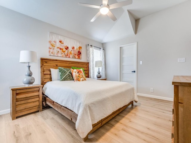 bedroom with light wood-style flooring, baseboards, and vaulted ceiling