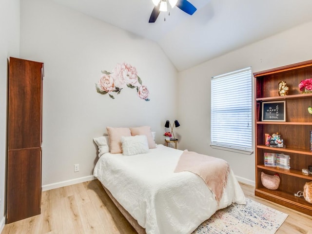 bedroom featuring baseboards, vaulted ceiling, light wood-style floors, and a ceiling fan