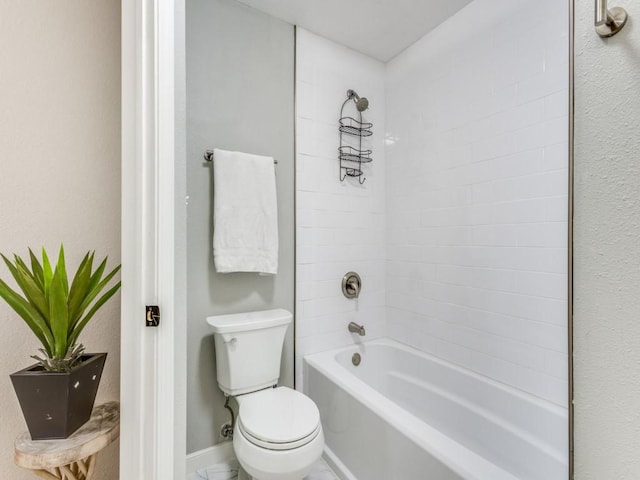 bathroom featuring baseboards, toilet, and shower / bathtub combination