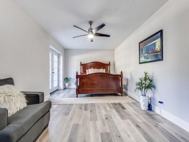 bedroom featuring baseboards, wood finished floors, and a ceiling fan