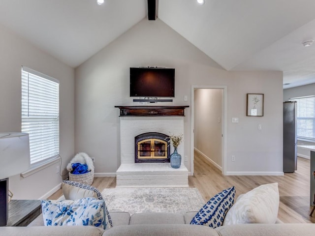 living room with a brick fireplace, lofted ceiling with beams, baseboards, and wood finished floors