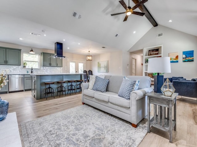 living area with visible vents, a healthy amount of sunlight, light wood finished floors, and ceiling fan