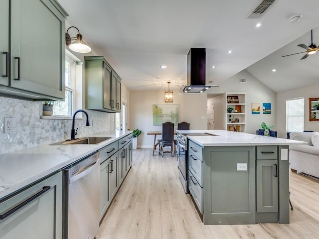 kitchen featuring green cabinets, open floor plan, stainless steel appliances, island exhaust hood, and a sink