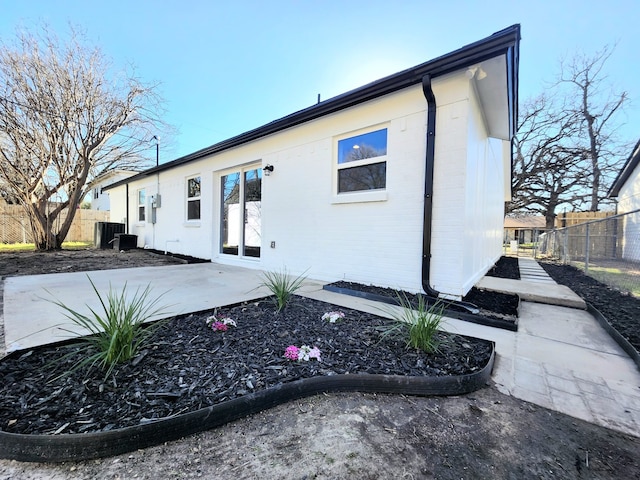 back of property featuring cooling unit, a patio, brick siding, and fence