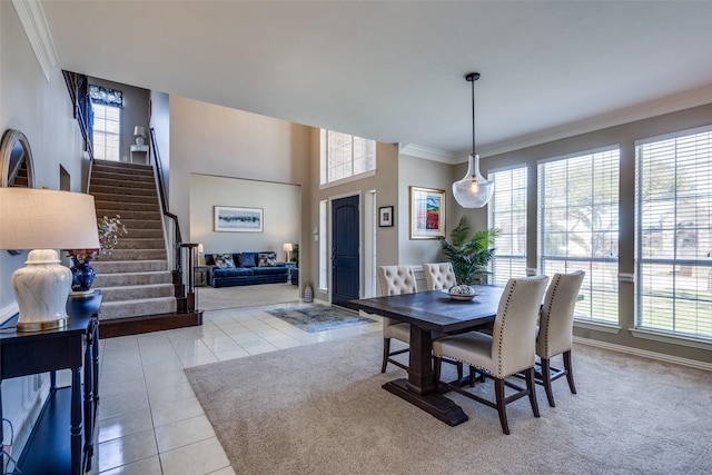 dining area featuring plenty of natural light, light tile patterned flooring, crown molding, and stairs