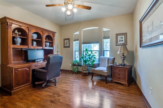 office area with wood finished floors, a ceiling fan, and baseboards