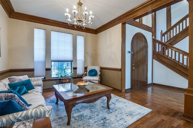 living room featuring baseboards, stairway, wood finished floors, an inviting chandelier, and crown molding