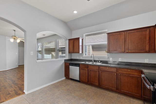 kitchen featuring a ceiling fan, dark countertops, lofted ceiling, appliances with stainless steel finishes, and a sink