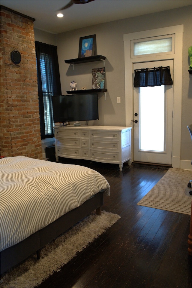 bedroom featuring brick wall, baseboards, hardwood / wood-style floors, and recessed lighting