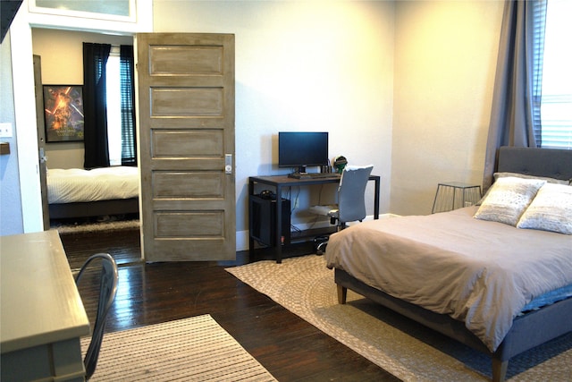 bedroom with baseboards and hardwood / wood-style flooring